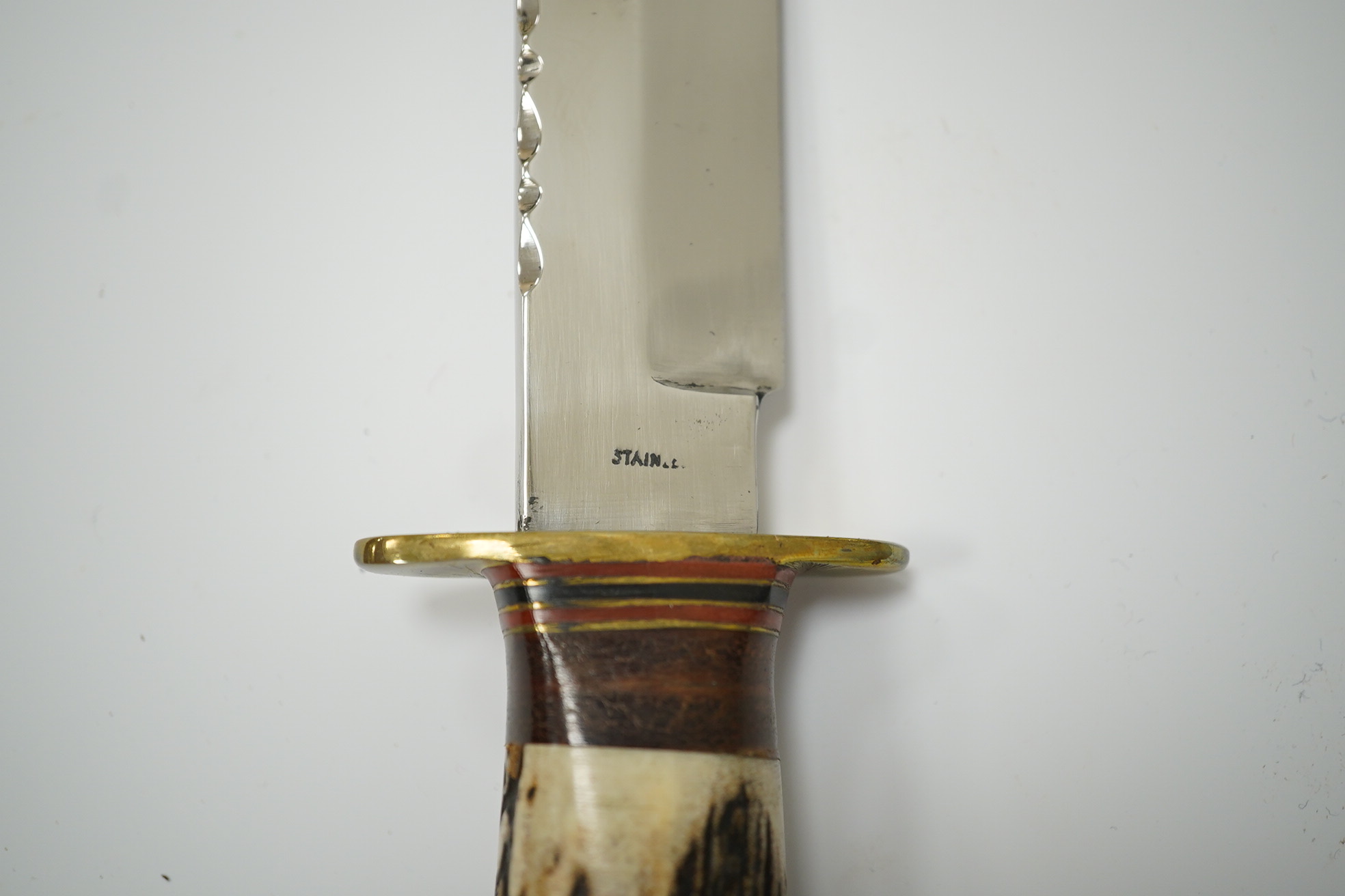 A small bowie knife by R. Cooper in its leather sheath, blade 15cm. Condition - good